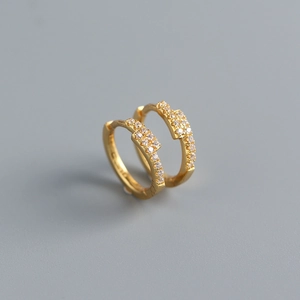 Macro view of gold S925 sterling silver hoop earrings set with shimmering cubic zirconia