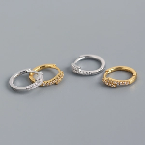 Macro shot of silver and gold S925 sterling silver hoop earrings with cubic zirconia stones