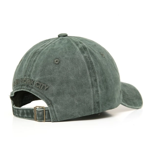 Detail of adjustable metal buckle and New York City embroidery on green washed cotton cap
