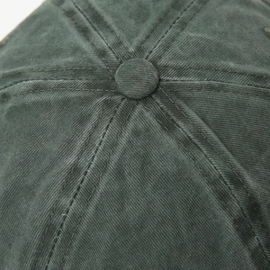 Macro detail of high-density twill cotton fabric and top button on dark green cap