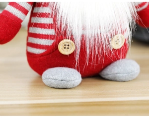 Détail du tissu tricoté et du bouton en bois d'un gnome de Noël nordique festif