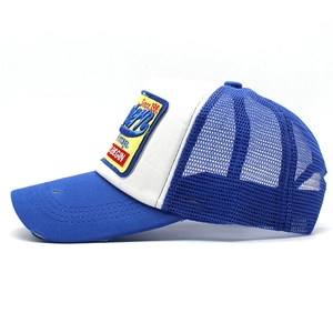Side view of blue trucker cap with vintage embroidery patch and distressed mesh detail