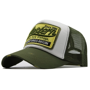 Detail of army green trucker hat with vintage Western patch and mesh ventilation