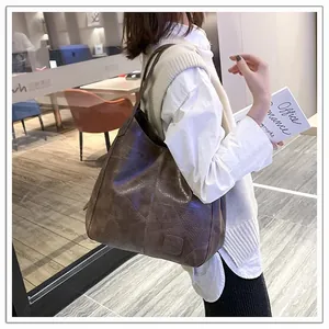 Brown vintage hobo tote bag in embossed leather shown on model for size reference