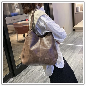 Detail of a large vintage brown leather tote bag with embossed geometric texture