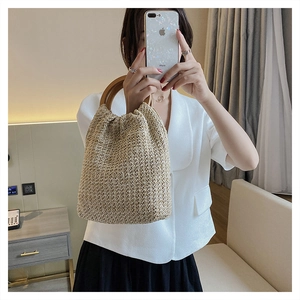 Detail of woven straw handbag with round wooden handles styled in a lifestyle mirror selfie