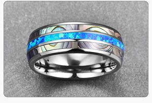 Macro shot of titanium steel ring featuring blue abalone shell inlay and polished finish