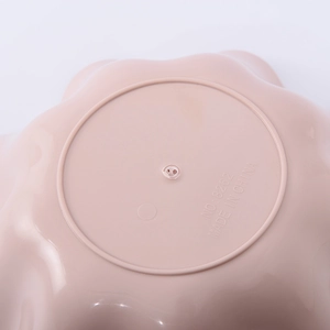 Bottom view of pink ruffled fruit bowl showing anti-slip ring and durable plastic material