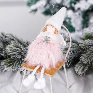 Handmade Christmas angel plush ornament in pink and white sitting on a wooden chair