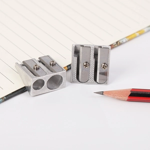 Dual-hole silver aluminum pencil sharpener shown on notebook with metal finish