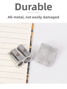 Close-up of double hole aluminum alloy metal pencil sharpener on a notebook
