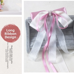 Detail of pink and white bow hair clip with organza ribbon and pearl center embellishment