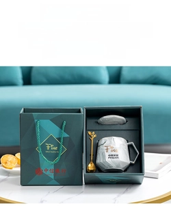 Detail of Nordic marble ceramic mug set with golden spoon and elegant gift packaging
