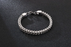 Macro detail of silver stainless steel wheat chain link bracelet with lobster clasp