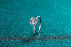 Macro shot of 925 silver moissanite ring with square halo setting on glitter background