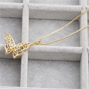 Gold butterfly pendant necklace with hollow wings and colorful gemstones on box chain