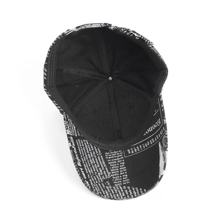 Gros plan d'une casquette de baseball noire avec imprimé journal vintage et détails