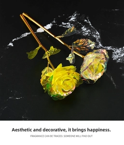 Macro view of two 24k iridescent gold foil artificial roses on black marble background