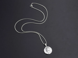 Detailed macro view of vintage silver steel coin pendant with portrait relief on box chain