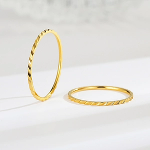 Dettaglio di due anelli in titanio oro rosa 18K con motivo sfaccettato in stile minimal