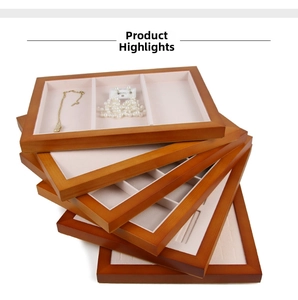 Detail of five wooden jewelry display trays with pink velvet lining for necklaces and rings