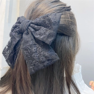 Elegant large double-layer black lace bow hair clip shown on a long hairstyle