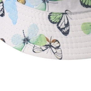 Detailed close-up of a white bucket hat featuring colorful butterfly prints and reinforced stitching