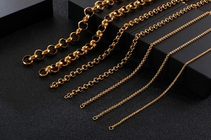 Detailed view of various sizes of golden O-chain necklaces on a black background