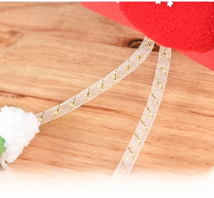 Detailed macro view of plush Christmas ornament legs with red felt and gold-threaded mesh