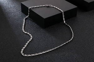 Detail of silver 304 stainless steel chain necklace draped over a black display box