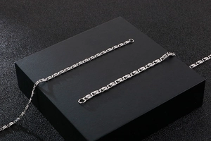 Macro shot of silver stainless steel chain necklace showing polished interlocking links