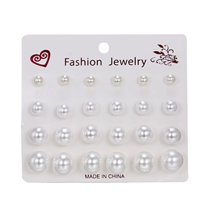 Close-up of 12 pairs of white pearl stud earrings in varying sizes on a display card