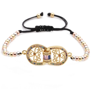 Detail of adjustable woven bracelet with gold-plated hollow heart and colored zircons