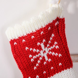 Classic red and white knitted Christmas stocking with snowflake patterns for holiday gifts