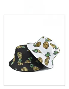 Detail of black and white cotton bucket hats featuring vibrant yellow pineapple prints