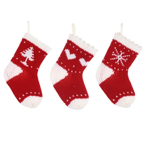 Three red and white knitted Christmas stockings with tree, heart, and snowflake patterns