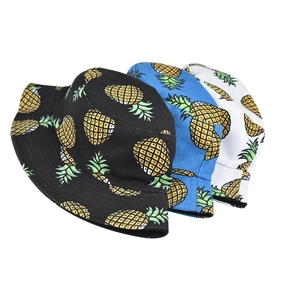 Close-up of pineapple print bucket hats in black, blue, and white breathable fabric