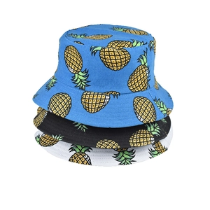 Detailed pattern of yellow pineapples printed on cotton canvas bucket hats in three colors