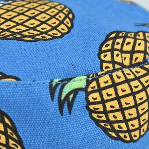 Detailed macro view of the pineapple print on durable cotton fabric of a bucket hat