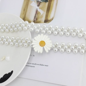 Détail de la chaîne de taille en perles à plusieurs rangs avec boucle fleur de marguerite