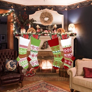 Detail of premium knitted Christmas stockings with snowflake and reindeer patterns by fireplace