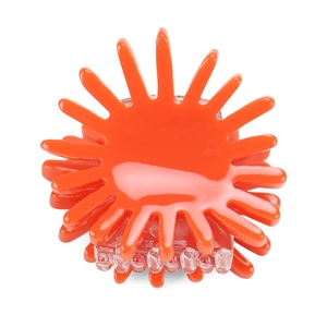 Detail shot of a bright orange flower-shaped hair claw clip with glossy finish