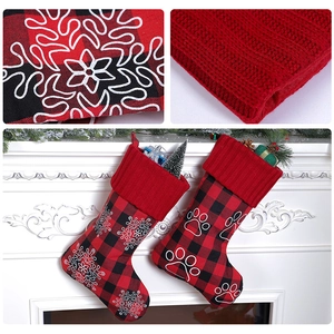 Detail of plaid Christmas stockings with embroidered snowflake and paw print on mantel
