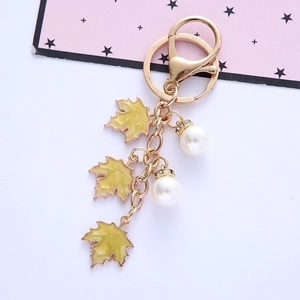 Maple leaf pearl keychain with gold metal lobster clasp on a clean white background