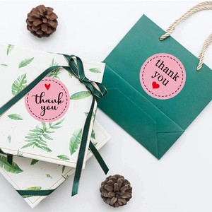Pink heart Thank You stickers on tropical gift box and dark green paper bag