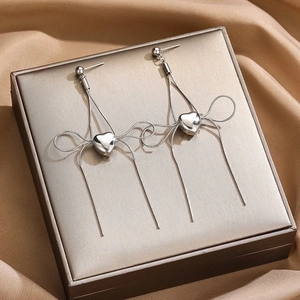 Silver stainless steel heart earrings with bow tassel chains on a premium display box