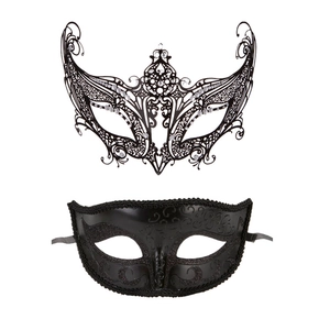 Detail of black laser-cut metal filigree and embossed masquerade mask set on white background