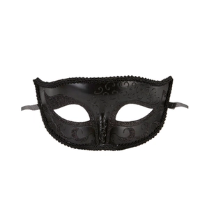 Detail of black laser-cut metal masquerade mask with ornate filigree and side ribbons