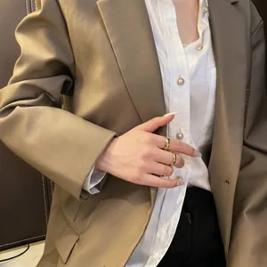 Trois bagues minimalistes en acier titane plaqué or 18K empilées sur une main