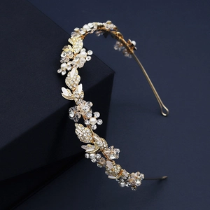 Détail d'un serre-tête de mariée avec feuilles dorées, cristaux et perles